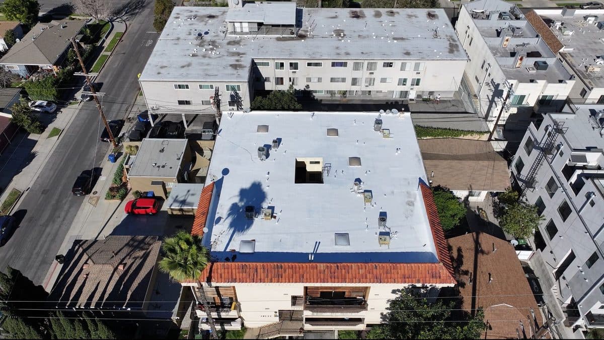 Aerial view of an apartment building flat roof with a clay tile edge and a central light well