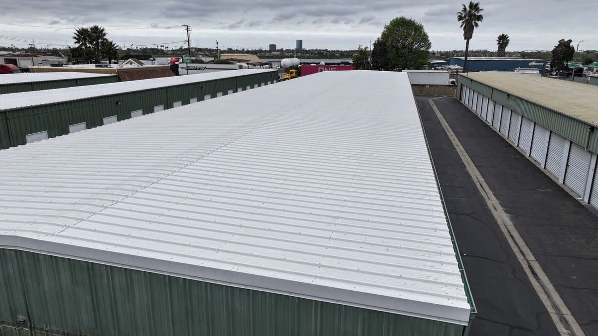 White roof on a long green building at a storage facility