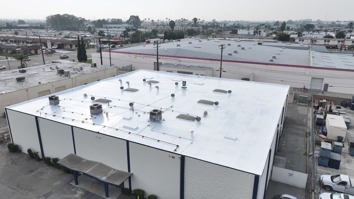 White flat roof on a commercial building with rooftop units and skylights