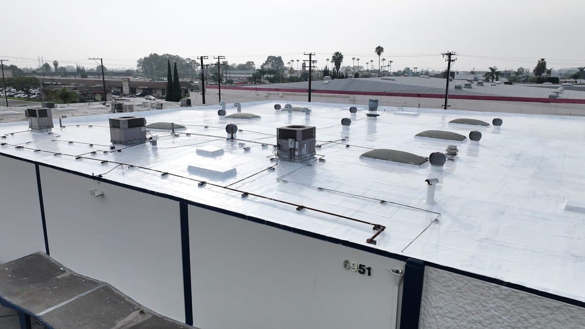 Low-angle view of a white flat roof edge with rooftop units