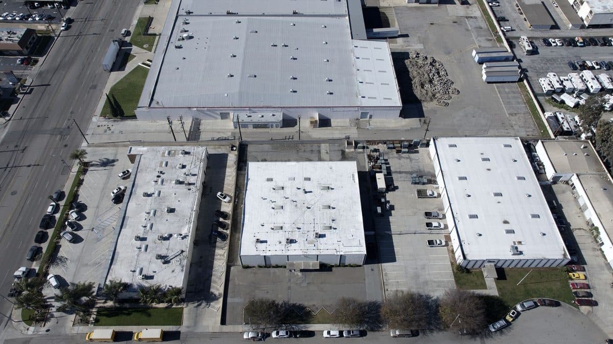 Aerial view of several commercial buildings with flat roofs in an industrial area