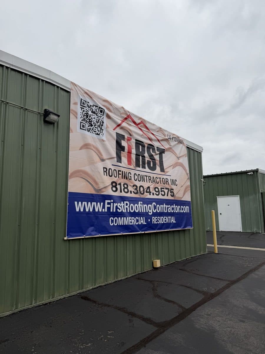 First Roofing Contractor banner on the side of a green commercial building