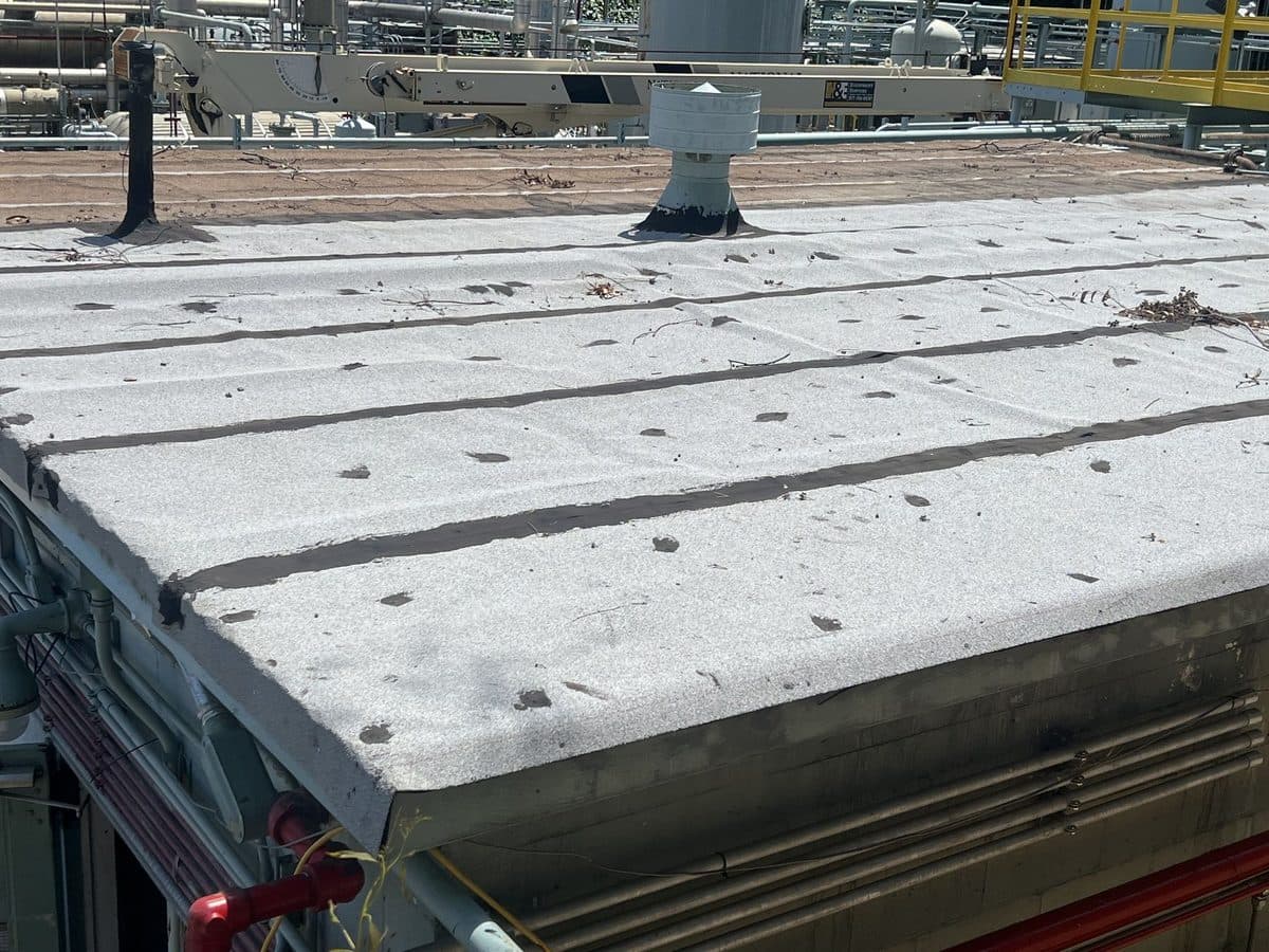 Close view of a flat roof surface and edge with seams at an industrial site
