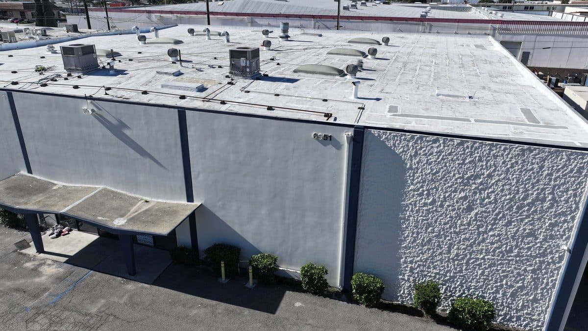 White flat roof of a commercial building with rooftop units