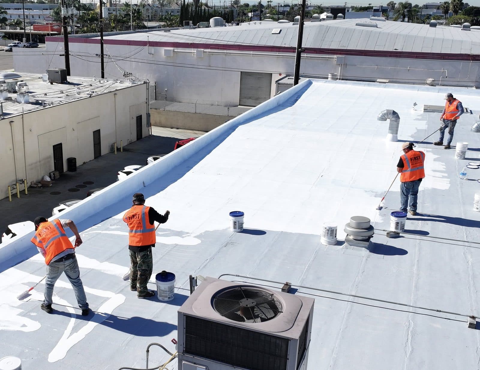 First Roofing Contractor crew working on a commercial low-slope roof in Southern California