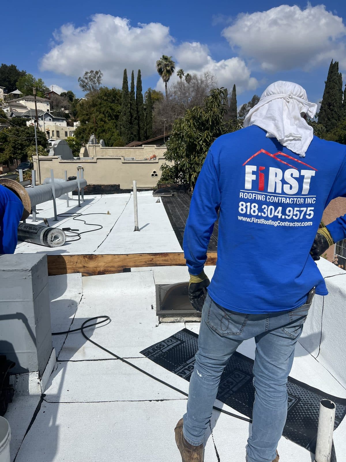 First Roofing Contractor crew member standing on a commercial roof