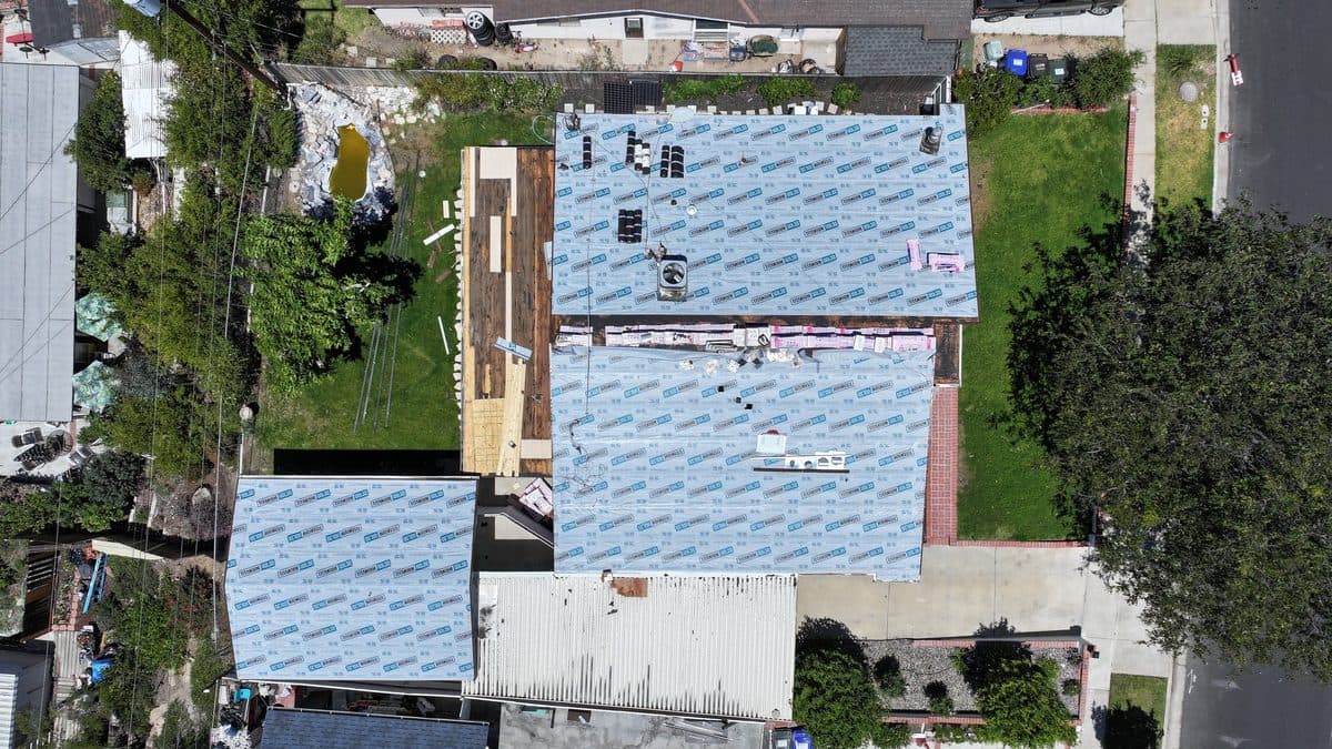 Aerial view of synthetic underlayment installed on multiple roof sections