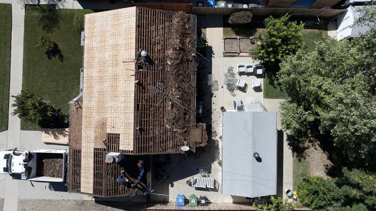 Aerial view of a roof tear-off with debris and exposed decking