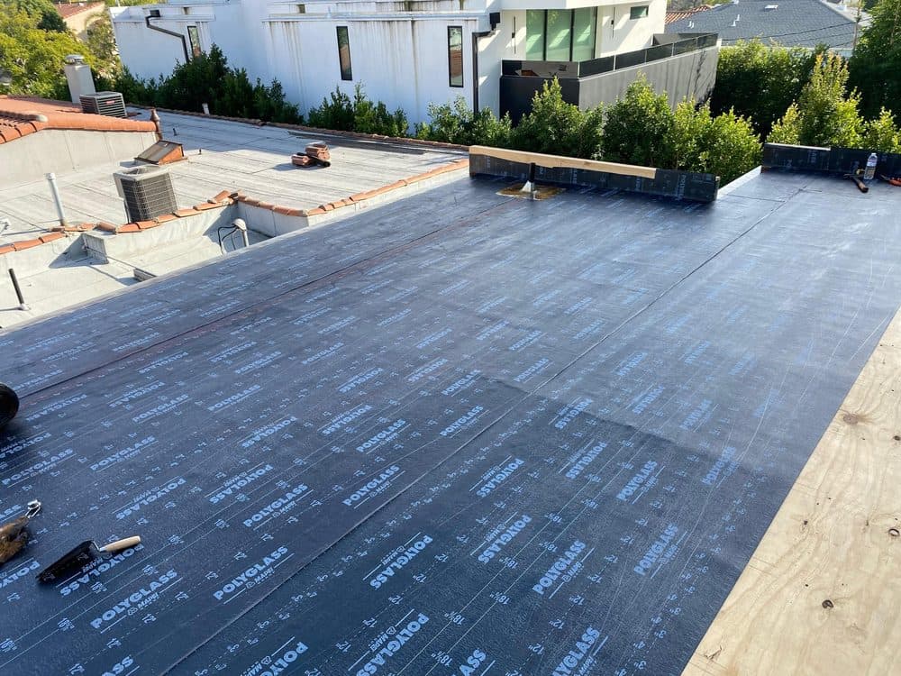 Flat roof re-roofing project with waterproof underlayment installed