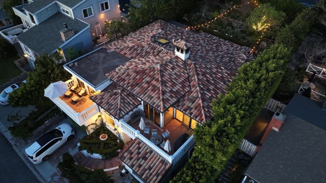 Aerial view of a completed multi-tone tile roof on a home at dusk
