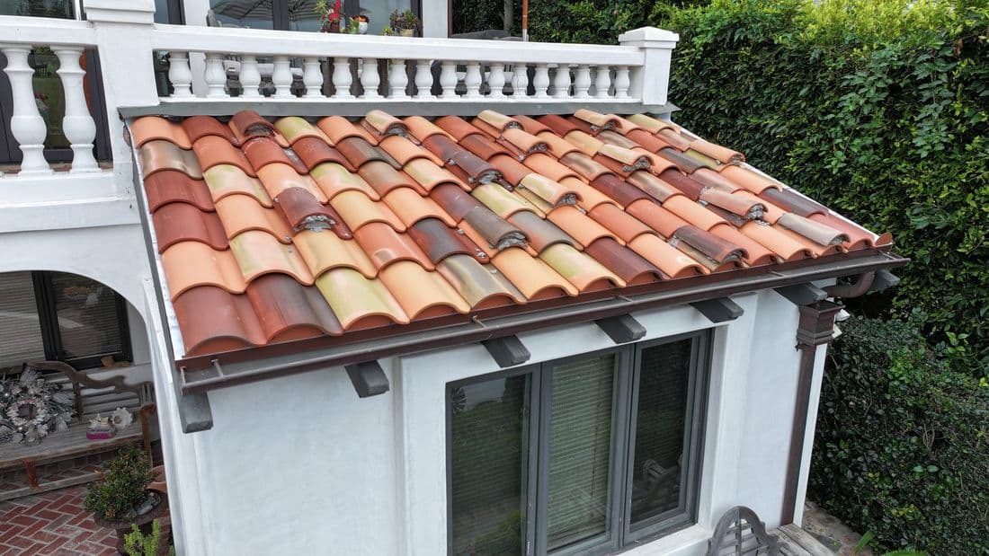 Close view of a multi-tone S-profile tile roof above a balcony