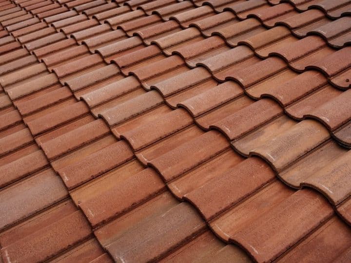 Concrete S-profile roof tiles in terracotta tones, close-up