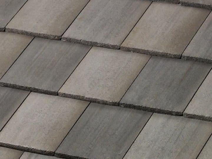 Flat concrete roof tiles in gray and brown tones, close-up